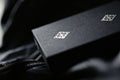 Madison Rounders White Playing Cards by Daniel Madison — brand logo detail on premium black leather surface