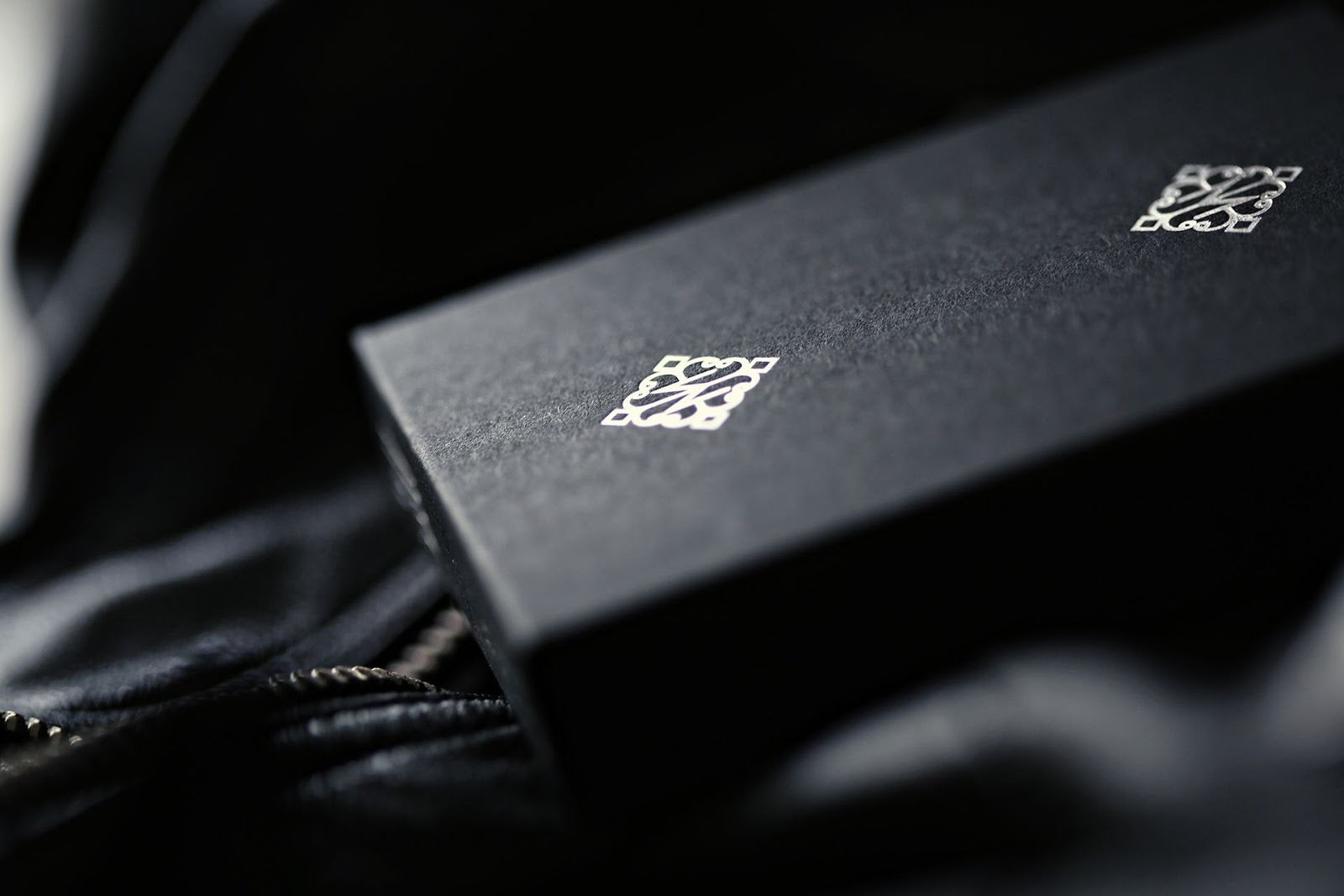 Madison Rounders White Playing Cards by Daniel Madison — brand logo detail on premium black leather surface