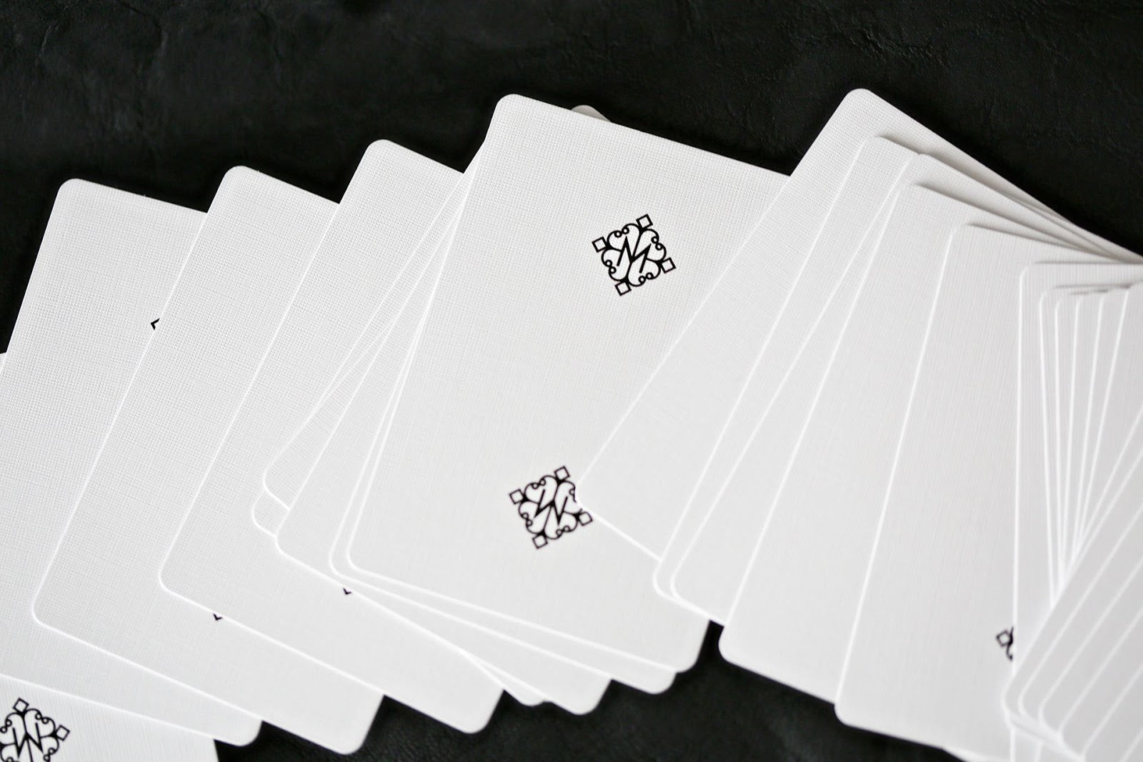 Madison Rounders White Playing Cards by Daniel Madison — full deck fanned on black background